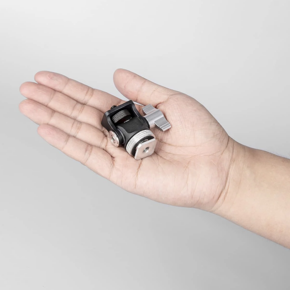 Hand holding a small Lumia Ball head against a plain background