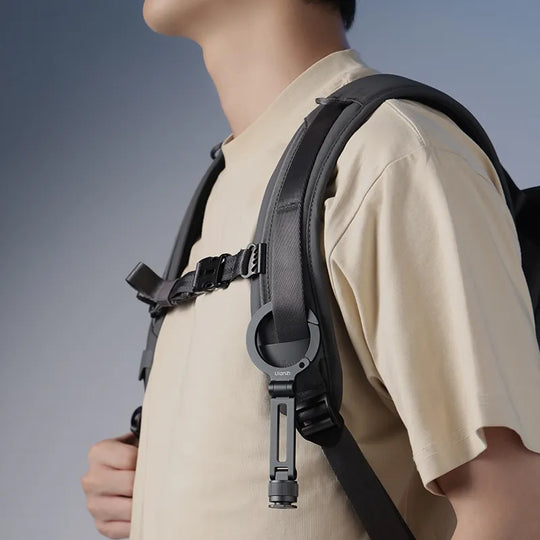 Person wearing a black backpack with a neutral background