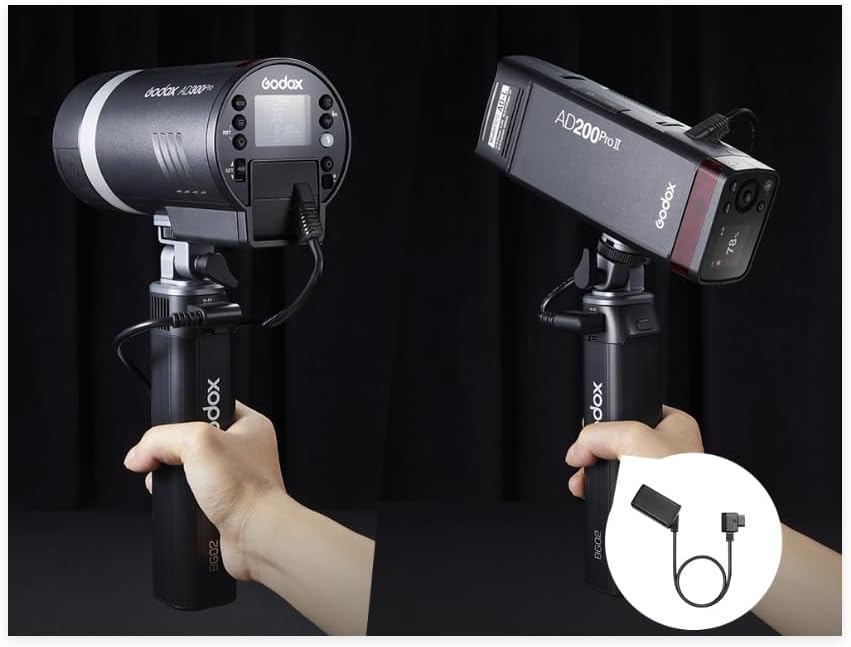 Two Godox studio lights held by hands with a black background