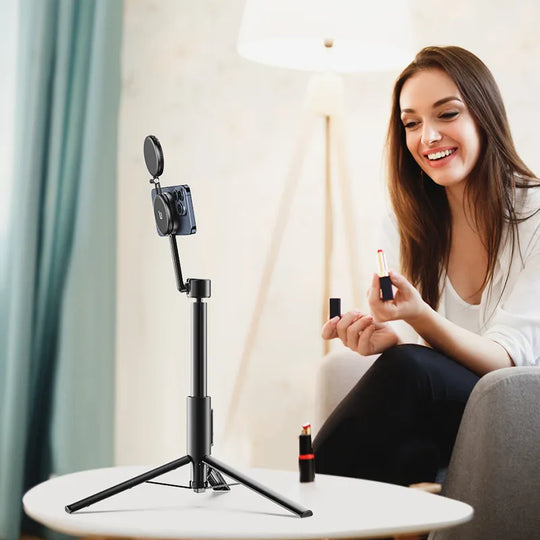 Woman holding a lipstick in front of a camera on a tripod in a home setting