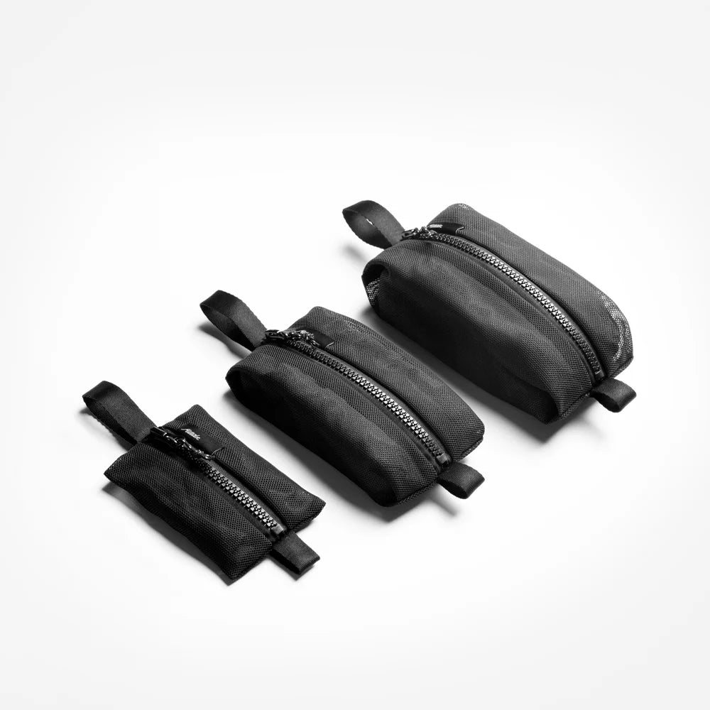 Set of black zippered mesh pouches on a white background