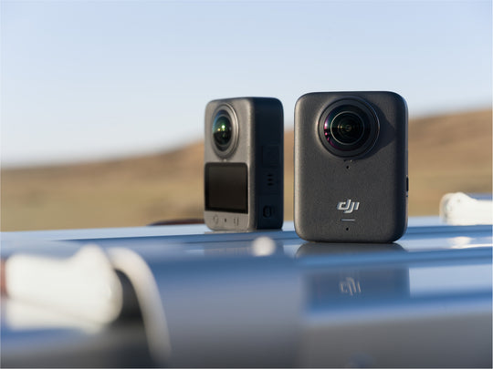 Two cameras on a car roof with a desert landscape in the background