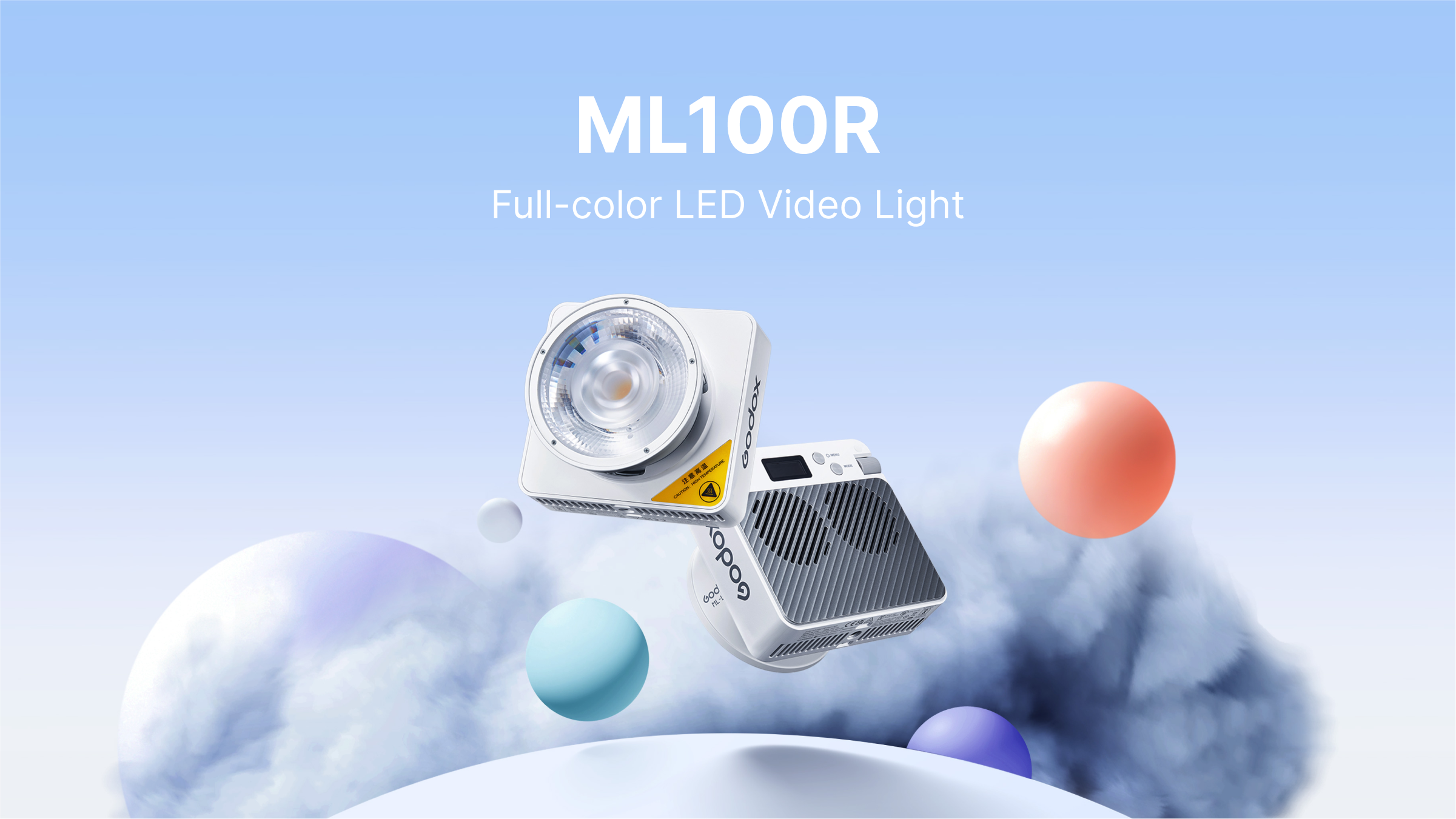 A white Godox ML100R LED video light and its compact power supply are displayed against a soft background of white clouds and pastel blue, pink, and purple spheres. The text 