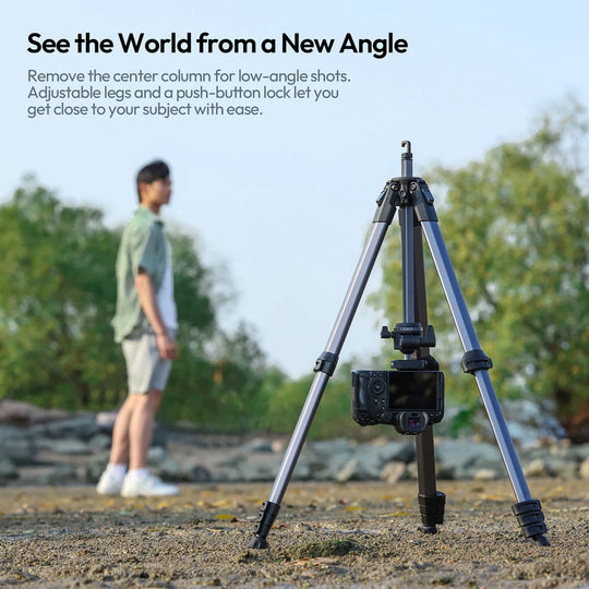 Tripod with adjustable legs and push-button lock in a natural setting with a person in the background.