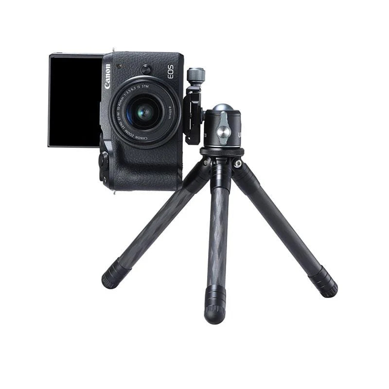 Canon camera on a small tripod with a white background