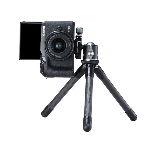 Canon camera on a small tripod with a white background